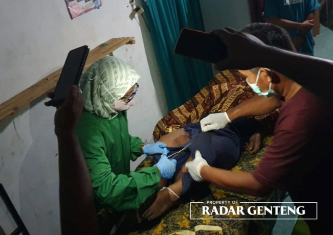 EVAKUASI: Petugas kesehatan memeriksa jenazah Rohman Wahyudi yang gantung diri di kuburan Dusun/Desa Kebondalem, Kecamatan Bangorejo, Senin (20/2) sore. (Foto: Gatot untuk JPRG)