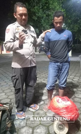 BARANG BUKTI: Supriadi dengan daging babi liar hasil buruannya di Blok Kilometer 9 Wilayah SPTN 1 TN Meru Betiri, Desa Sarongan, Kecamatan Pesanggaran diamankan anggota Polsek Pesanggaran, Senin (20/2) malam. (Foto: Basori untuk JPRG)