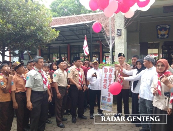 SIMBOLIS: Ketua Kwarcab Banyuwangi H Sugirah (pegang mix), Kepala SMPN 2 Srono Slamet Subagyo (lima dari kanan) saat akan melepas balon disaksikan Kasi Mutu SMP Didik Eka Wahyudi, Camat Srono Tri Wahyu Angembani dalam dies natalis ke-31 SMPN 2 Srono, pada