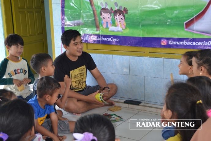 CERIA: Adi Prayugo mendongeng pada anak-anak di Taman Baca Ceria, Dusun Bayatrejo, Desa Wringinpitu, Kecamatan Tegaldlimo, Minggu (12/2). (Foto: Lugas Rumpakaadi/JPRG)