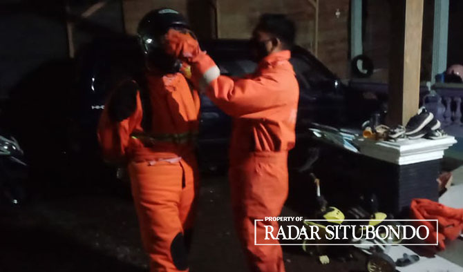 PERSIAPAN: Dua orang petugas Damkar menggunakan baju anti panas saat mengevakuasi sarang tawon di rumah warga, Desa Klatakan, Kecamatan Kendit, Senin malam (27/3). (Dok. Damkar untuk Radar Situbondo)
