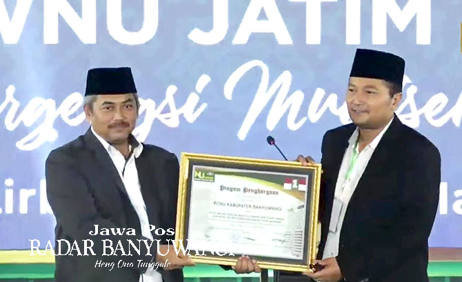 Ketua PCNU Banyuwangi, H.Mohamad Ali Makki (kanan) menerima penghargaan sebagai PCNU Terfavorit dari Ketua Panitia NU Award PWNU Jatim Moh. Koderi di Pondok Pesantren Lirboyo, Kediri, Sabtu malam (18/3). (Dedy Jumhardiyanto/Radar Banyuwangi)