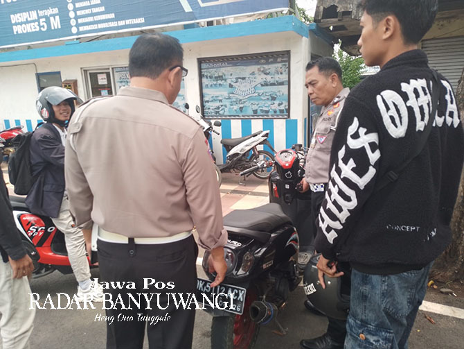 TEGAS: Kanitlantas Polsek Rogojampi Iptu Akriyanto merazia motor dengan knalpot brong di depan Pos Lantas Rogojampi, Kamis (30/3). (Dedy Jumhardiyanto/Radar Banyuwangi)
