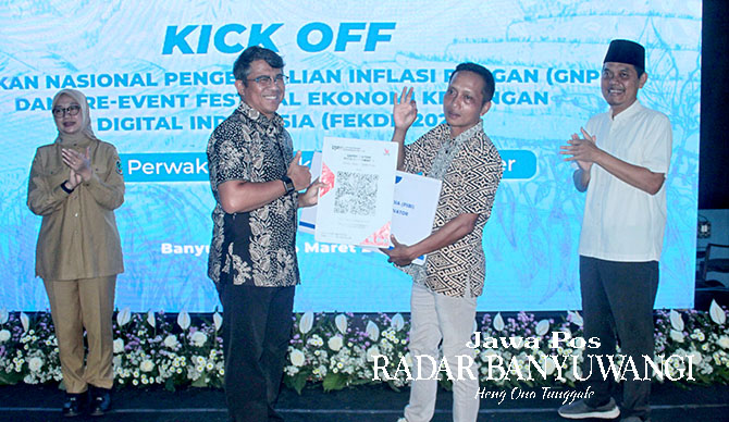 SERAH TERIMA: Kepala Perwakilan (KPw) Bank Indonesia Jember Yukon Afrinaldo (dua dari kiri) menyerahkan secara simbolis QRIS kepada Ketua Gapoktan Turi Putih Tri Wahyudi (dua dari kanan) didampingi Bupati Banyuwangi Ipuk Fiestiandani (kiri) dan anggota Ko