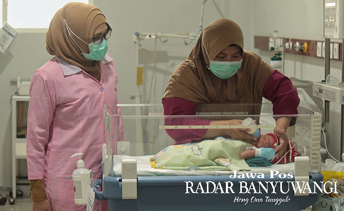 SEHAT: Direktur RSUD Genteng Siti Asiyah Anggraeni (kiri) dan perawat memberikan susu formula kepada bayi di ruang perawatan khusus bayi, Selasa (14/3). (Salis Ali/Radar Genteng)