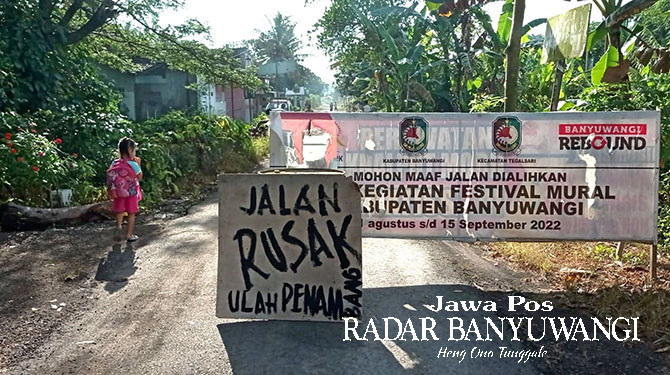 DITUTUP: Jalan raya di Dusun Krajan 1, Desa/Kecamatan Tegalsari jurusan Desa Tegalrejo, Kecamatan Tegalsari oleh warga ditutup karena rusak akibat dilalui dump truck muatan material, Jumat (17/3). (Salis Ali/Radar Genteng)