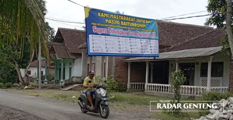 TOLAK MAKAM: Warga membentangkan banner penolakan makam di tanah wakaf Masjid Baiturrohim, Dusun Sumberwaru, Desa Tamanagung, Kecamatan Cluring, Minggu (26/3). (Foto: Lugas Rumpakaadi/JPRG)