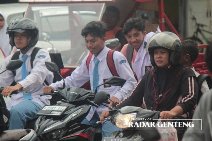 LANGGAR ATURAN: Siswa tanpa mengenakan helm saat naik motor di Jalan Gajah Mada, Desa Genteng Kulon, Kecamatan Genteng, Rabu (8/3). (Foto: Salis Ali/JPRG)