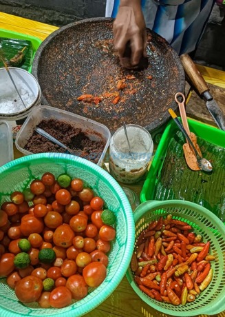 MANUAL: Cabai, tomat, terasi, garam, gula, dan perangkat pembuat sambal berupa cobek dan ulek-ulek. (Ramada Kusuma/RadarBanyuwangi.id)