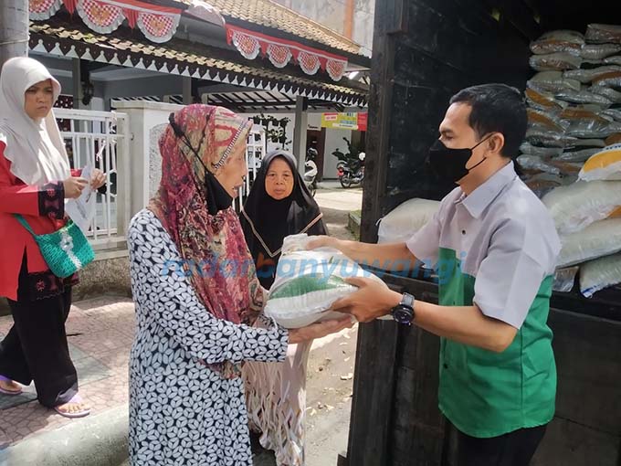 TERIMA BANSOS: Petugas menyalurkan beras medium kemasan 10 kilogram kepada KPM di Kelurahan Sobo kemarin (11/4).