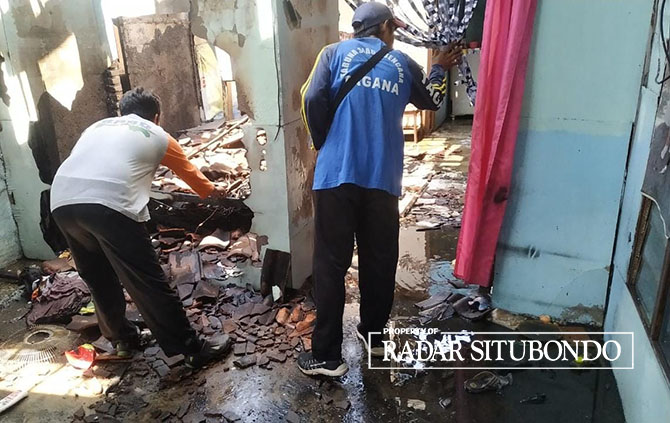 TERBAKAR: Anggota BPBD melakukan kaji cepat di rumah milik Suryati, warga Dusun Pecinan Utara, Desa Tanjung Pecinan, Kecamatan Mangaran, Jumat (14/4). (Humaidi/Radar Situbondo)