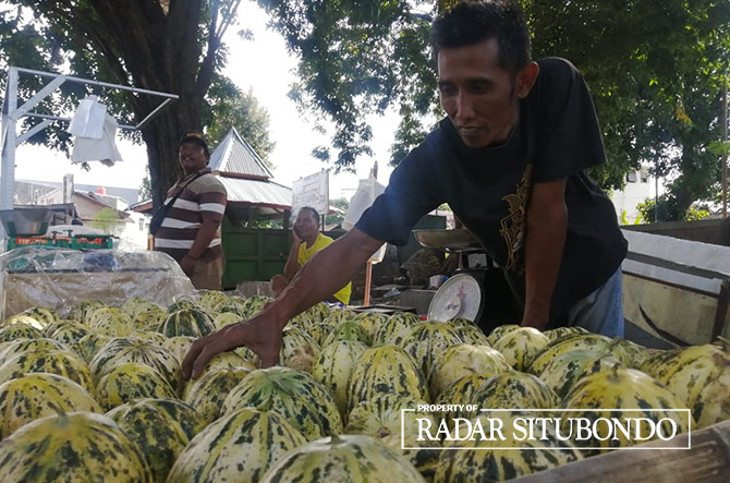 TURUN HARGA: Pedagang Blewah di pinggir Jalan Raya Kecamatan Panji, Situbondo, menawarkan barang dagangannya kepada pembeli. (Humaidi/Radar Situbondo)