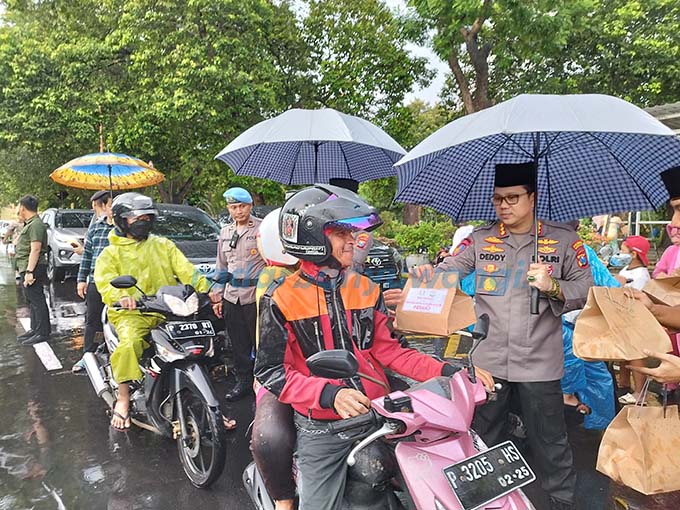 BERBAGI BERKAH: Ketua Bhayangkari Reny Deddy Millewa bersama Kapolresta Kombespol Deddy Foury Millewa membagikan takjil kepada para pengendara yang melintas di Jalan Jenderal Sudirman kemarin (10/4). (Bagus Rio/RadarBanyuwangi.id)