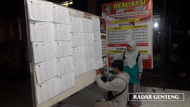PASANG DPS: PPS Desa Purwodadi, Kecamatan Gambiran memasang nama-nama DPS di papan pengumuman kantor desa setempat, Rabu (12/4) malam. (Foto: Luga Rumpakaadi/JPRG)