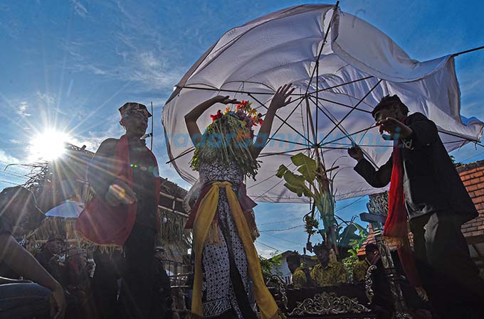TERIK: Dwi Putri Ramadani menari mengikuti irama gamelan dan gending Oseng dengan mata terpejam di arena ritual adat seblang, Desa Olehsari, Kecamatan Glagah, kemarin (25/4). (Ramada Kusuma/RadarBanyuwangi.id)