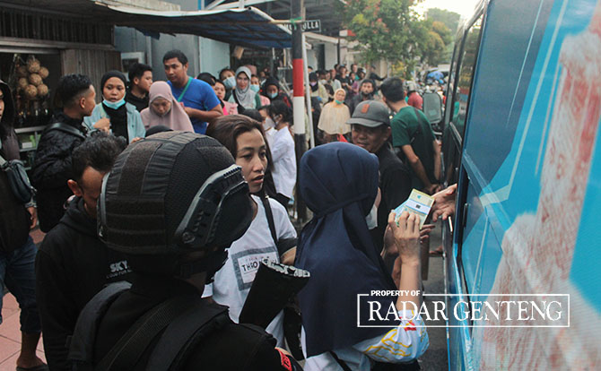 MENGULAR: Antrean warga yang hendak menukarkan uang pecahan di bootoh penukaran uang oleh Bank Indonesia (BI) di depan Pasar Genteng 1, Desa Genteng Kulon, Kecamatan Genteng, Senin (17/4). (Salis Ali/Radar Genteng)