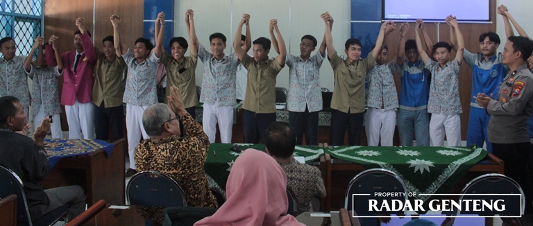 SALING BERJABAT: Perwakilan siswa SMK Muhammadiyah 2 Genteng, SMK Muhammadiyah 6 Rogojampi, dan SMAN 1 Genteng saling bergandengan tanda damai disaksikan anggota TNI, polisi, dan PDM Banyuwangi, Rabu (5/4). (Foto: Salis Ali/JPRG)