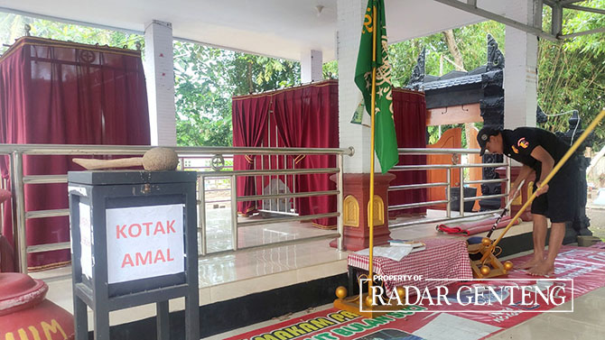 RAWAT MAKAM: Pengurus makam Irawan Suyanto membersihkan makam yang dipercaya pesarean Prabu Tawang Alun di Dusun Sukodadi, Desa Sraten, Kecamatan Cluring, Jumat (14/4). (Lugas Rumpakaadi/Radar Genteng)