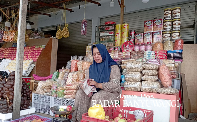 SENANG: Penjual kue Lebaran di Pasar Jajag, Kecamatan Gambiran senang pembeli telah naik, Rabu (19/4). (Lugas Rumpakaadi/Radar Genteng)