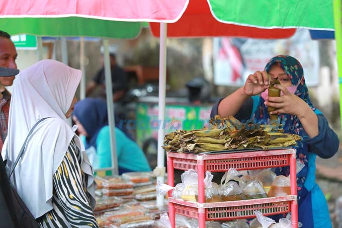 PERPUTARAN EKONOMI: Pedagang dan pembeli melakukan transaksi jual beli di pasar takjil jalan letjen Sutoyo Banyuwangi. (Dini Untuk RadarBanyuwangi.id)