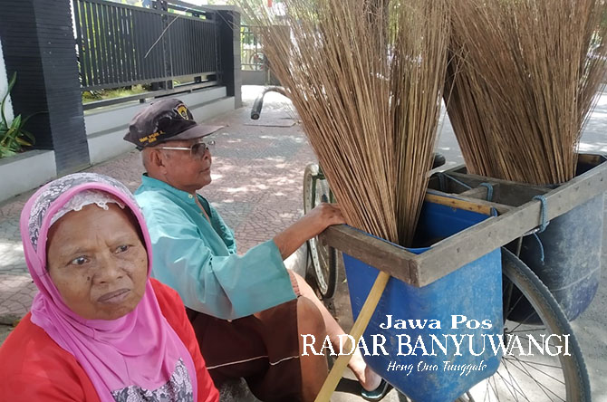 MENUNGGU PEMBELI: Mansur dan Jamila beristirahat setelah berjalan menjajakan dagangannya di depan kantor Dinas Koperasi Usaha Mikro dan Perdagangan Banyuwangi, Rabu (12/4). (Gareta Wardani/Radar Banyuwangi)