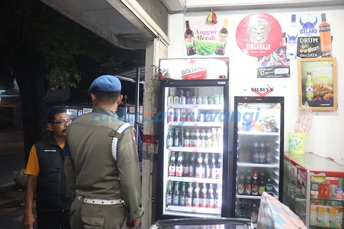 DIMINTA TUTUP: Petugas Satpol PP mendapati toko Ofak di Banyuwangi yang masih menjual miras,  Sabtu malam (1/4). (Ramada Kusuma/RadarBanyuwangi.id)