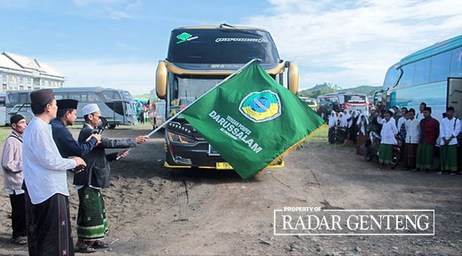 DILEPAS: KH Ahmad Mubasyir Syafaat didampingi Kiai Asyikin (kiri) melepas bus yang membawa para santri Pondok Pesantren Darussalam Blokagung pulang kampung, kemarin (7/4). (Salis Ali/Radar Genteng)