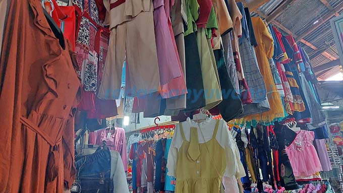 BELUM LAKU: Beragam jenis pakaian anak hingga dewasa masih menggantung di lapak-lapak pedagang Pasar Banyuwangi kemarin (24/4). (Ayu Lestari/RadarBanyuwangi.id)