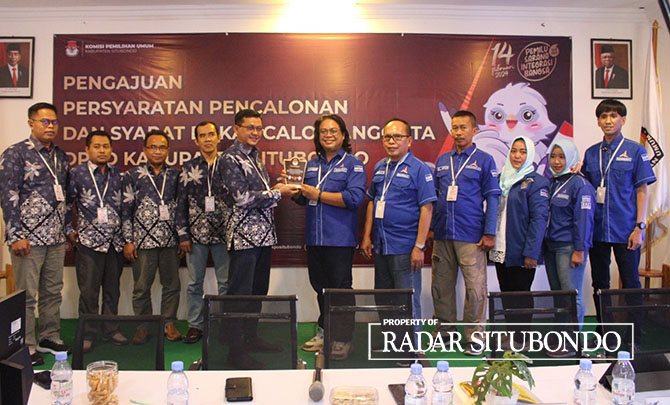BERSERAGAM: Ketua DPC Partai Demokrat, Janur Sasra Ananda menerima cinderamata dari Ketua KPU, Marwoto di aula KPU, Minggu (14/5) kemarin, usai menyerahkan berkas pengajuan bacaleg. (Iwan Feriyanto/Radar Situbondo)