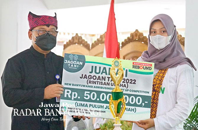 SIMBOLIS: Sekkab Mujiono menyerahkan stimulus modal usaha kepada Juara I Jagoan Tani 2022 di pendapa Sabha Swagata Blambangan. (Dini untuk Radar Banyuwangi)