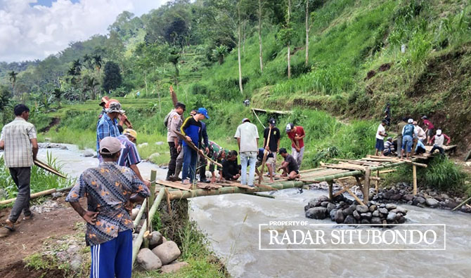 GOTONG ROYONG: Warga bersama jajaran Forkopimcam Sumbermalang membangun jembatan darurat dari batang bambu di Sungai Deluweng, Desa Sumberargo, Kecamatan Sumbermalang, belum lama ini. (Polres Situbondo untuk JPRS)