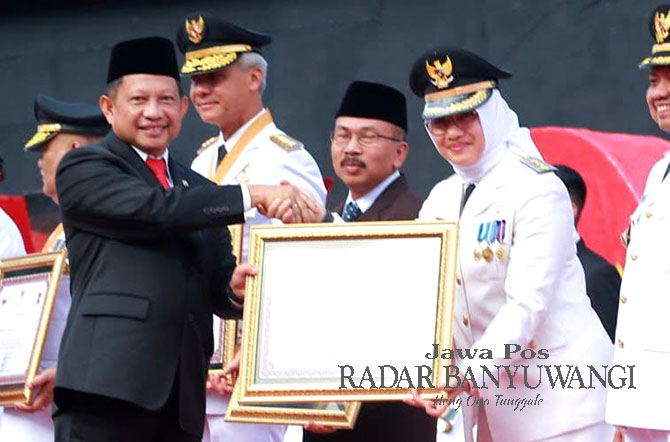 BUAH INOVASI: Mendagri Tito Karnavian menyerahkan piagam penghargaan kinerja pemerintah daerah terbaik kategori kabupaten kepada Bupati Ipuk Fiestiandani pada rangkaian upacara peringatan hari Otda di Makassar, Sulawesi Selatan, Sabtu (29/4). (Dini untuk