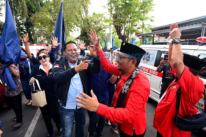 TETAP SEDULURAN: Ketua DPC PDIP Banyuwangi Made Cahyana Negara bersama bacaleg dari NasDem berjoget mengikuti irama lagu Umbul-Umbul Blambangan di depan kantor KPU Banyuwangi kemarin (11/5). (Ramada Kusuma/RadarBanyuwangi.id)