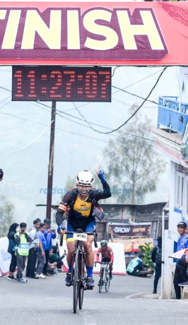RAJA TANJAKAN: Pembalap Banyuwangi Guntur Priambodo menyentuh garis finis Bromo KOM Challenge 2023 setelah menempuh jarak 100 km dari Surabaya menuju Desa Wonokitri, Kecamatan Tosari, Pasuruan, Sabtu (27/5/2023). (Ramada Kusuma/RadarBanyuwangi.id)