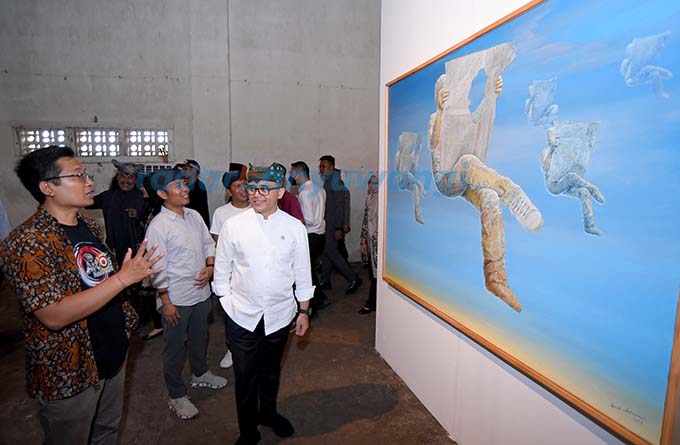 KARYA BUDI UBRUK: Menpan-RB Abdullah Azwar Anas didampingi kurator Samsudin Adlawi dan Presiden ArtOs Nusantara Imam Maskun mendapatkan penjelasan lukisan berjudul ”Enjoy Your Life” dari kurator Wayan Seriyoga. (Ramada Kusuma/RadarBanyuwangi.id)