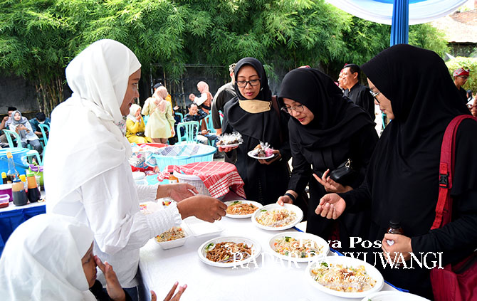 Bupati Ipuk Fiestiandani mencicipi nasi goreng di acara halalbihalal yang digelar di Grha Pena Banyuwangi, Selasa (2/5). (Ramada Kusuma/Radar Banyuwangi)