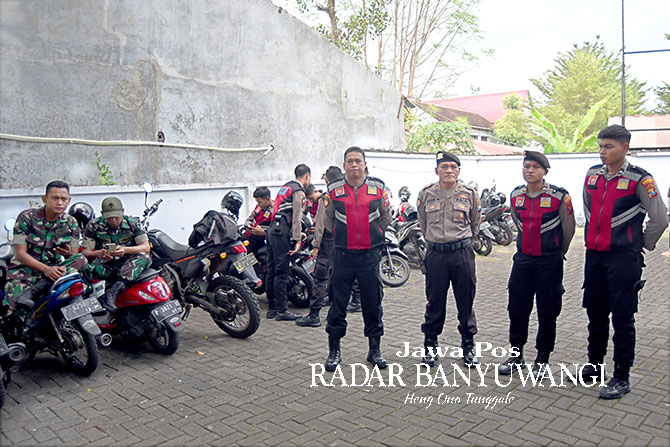 PENGAMANAN: Sejumlah personel kepolisian bersiaga di kantor KPU Banyuwangi untuk mengamankan proses pendaftaran caleg. (Ramada Kusuma/Radar Banyuwangi)