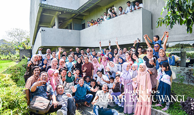 SELALU CERIA: Keluarga besar Jawa Pos Radar Banyuwangi berfoto bersama dengan view gedung Grha Pena, Selasa (2/5).  (Ramada Kusuma/Radar Banyuwangi)
