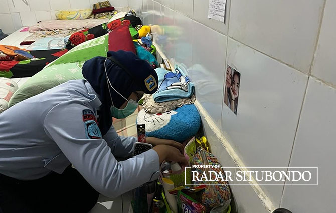 DIGELEDAH: Petugas Rutan Kelas IIB Situbondo memeriksa barang terlarang di kamar WBP, Senin malam (8/5). (Humaidi/Radar Situbondo)
