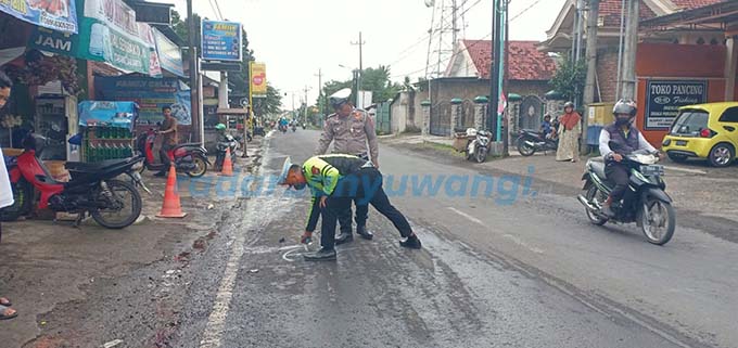 DATANGI TKP: Anggota Satlantas menandai lokasi kecelakaan yang menimpa Bagus Hadi Pramono di jalan raya Rogojampi, kemarin (11/5). (Satlantas untuk RadarBanyuwangi.id)