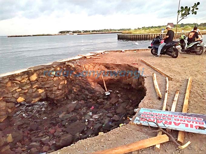 BERLUBANG: Tanah di pinggir plengsengan di wilayah Kelurahan Lateng, Kecamatan Banyuwangi, ambrol karena tergerus air laut. (Ramada Kusuma/RadarBanyuwangi.id)