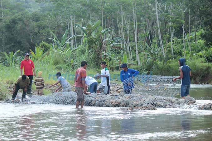 LAGI-LAGI: Warga kerja bakti membangun tanggul di Sungai Karangtambak, Dusun Sumberjambe, Desa Kandangan, Kecamatan Pesanggaran, kemarin (14/5).  (Salis Ali/RadarBanyuwangi.id)