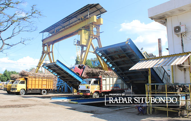 MODERN: Tebu yang diangkut menggunakan truk dipindah ke dalam alat penggiling untuk diproses jadi gula di PG Asembagus, Desa Trigonco, Kecamatan Asembagus, Rabu (7/5). (Iwan Feriyanto/Radar Situbondo)