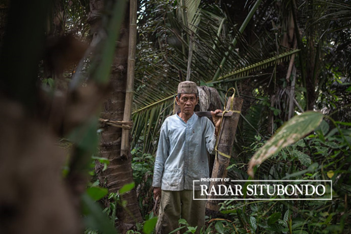 PULANG KERJA: Misto, warga Dusun Oloh, Desa Patemon, Kecamatan Bungatan, memikul nira dari hutan menuju rumahnya, belum lama ini. (Humaidi/Radar Situbondo)