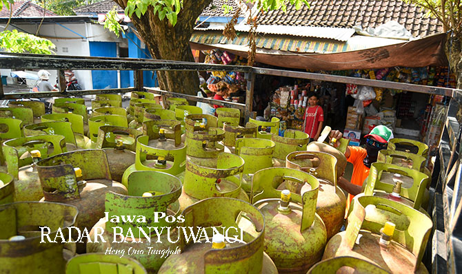MASIH BERSEGEL: Pekerja menurunkan elpiji kemasan tabung 3 kilogram di salah satu warung di Banyuwangi, Selasa (6/6). (Ramada Kusuma/Radar Banyuwangi)