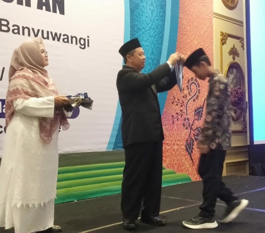 MOMEN SAKRAL: Ketua Yayasan Al Uswah Karyono saat mewisuda para siswa/siswi SDIT Al Uswah Kalipuro acara perpisahan dan apresiasi Al Quran di Hall ASTON Hotel Banyuwangi, Minggu (4/6/2023), (Sidrotul Muntaha/RadarBanyuwangi.id)