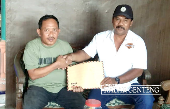 MINTA KEJELASAN: Ketua AMPD Ponirin (kanan) menyerahkan surat pada ketua BPD Agus Khoeroni pada Kamis (1/6). (Lugas Rumpakaadi/Radar Genteng)