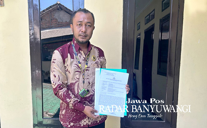 MINTA KEJELASAN: Kuasa hukum keluarga Devi Mayang Sari, Nurabidin, menunjukkan bukti laporan ke Polresta Banyuwangi beberapa waktu lalu. (Bagus Rio/Radar Banyuwangi)