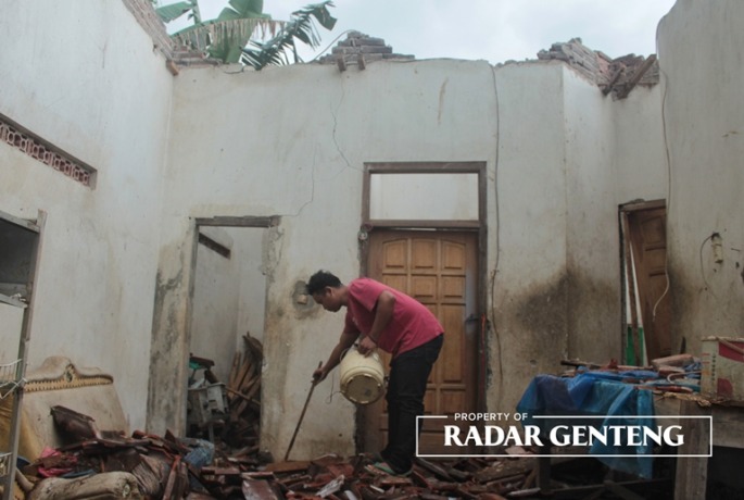 LESU: Pemilik rumah, Ahmad Lukman Pratama mengaisi beberapa barang yang tertimpa reruntuhan rumahnya, Dusun Simbar, Desa Karangsari, Kecamatan Sempu, Kamis (8/6). (Foto: Salis Ali/JPRG)