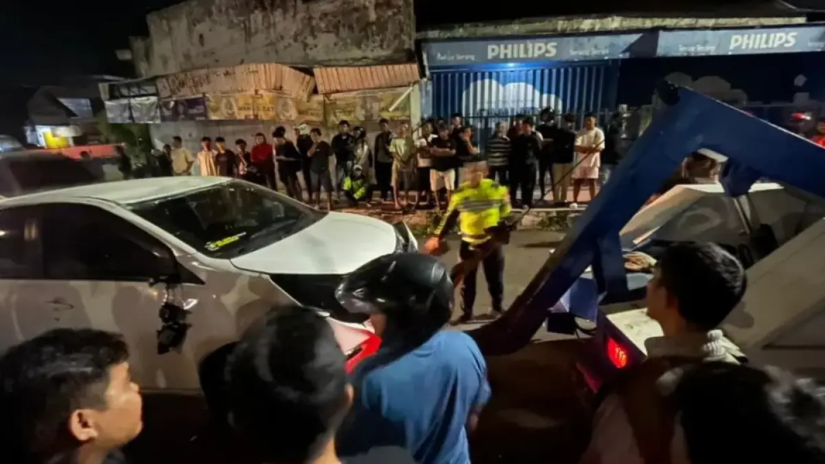 Petugas Satlantas Polres Jember saat melakukan proses evakuasi mobil Daihatsu Sigra yang terbalik di Jalan Trunojoyo pada Rabu malam guna memastikan arus lalu lintas kembali normal dan aman bagi kamu para pengguna jalan. (rifki/halojember)